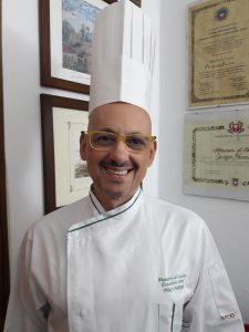 Una ricetta semplice e veloce, che racchiude la freschezza del mare e la leggerezza delle verdure in una presentazione raffinata ed elegante. È la Cupoletta di cernia con zucchinette e pistacchi di Bronte su vellutata di pesce allo Zafferano dello chef Pino Farina, per portare a tavola un piatto da chef con il quale stupire i vostri commensali. Cupoletta di cernia su vellutata di pesce - Ingredienti Per la cupoletta: •300 gr di filetti di cernia • 200 gr di zucchine tagliate a fette e sbollentate • 150 gr di pan grattato • 70 gr di pistacchi tritati • 70 gr di olio extra vergine d’oliva • 70 gr di prezzemolo tritato • 3 gr di sale • 2 gr di pepe Per la vellutata di pesce allo zafferano: • 500 gr di brodo di pesce • 5 gr di zafferano • 60 gr di burro • 60 gr di farina 00 • 2 gr di pepe bianco • 3 gr di sale Per la decorazione: • 50 gr di buccia di melanzana tagliata a julienne e fritta Procedimento. Foderare 4 formine mezze sfere da 100 gr con i filetti di cernia e le zucchine. Farcire con pan grattato aromatizzato all’olio extra vergine d’oliva, pistacchi e prezzemolo. Chiudere con le zucchine ed infornare a 180°C per 10 minuti. Servire con il fumetto (legato) di pesce allo zafferano, adagiarvi sopra la cupoletta e guarnire con la buccia di melanzana fritta (vedi foto). Lo chef Pino Farina Pino Farina è uno chef che vive il suo lavoro con serietà ed entusiasmo. Nato a Pantelleria, è cresciuto in un ambiente semplice nel quale ha imparato sin da subito a valorizzare i principi di onestà e rispetto per il lavoro, trasmessi dalla famiglia. L’amore per la cucina, nato negli anni Settanta, porta Pino Farina in prestigiosi ristoranti, sia in Italia che all’estero e durante la sua carriera consegue numerosi riconoscimento di merito, che lo riportano ai sapori e agli odori della sua terra, la Sicilia.Oggi lo chef Pino Farina è un affermato professionista riconosciuto executive chef da associazioni di categoria nazionali quali la F.I.C. ente nazionale, iscritto al club degli chef di Palermo.Insignito al “Collegium Cocorum” e riconosciuto Maestro di cucina ed Executive chef, attualmente chef Pino Farina è responsabile di una struttura per ricevimenti e banqueting.